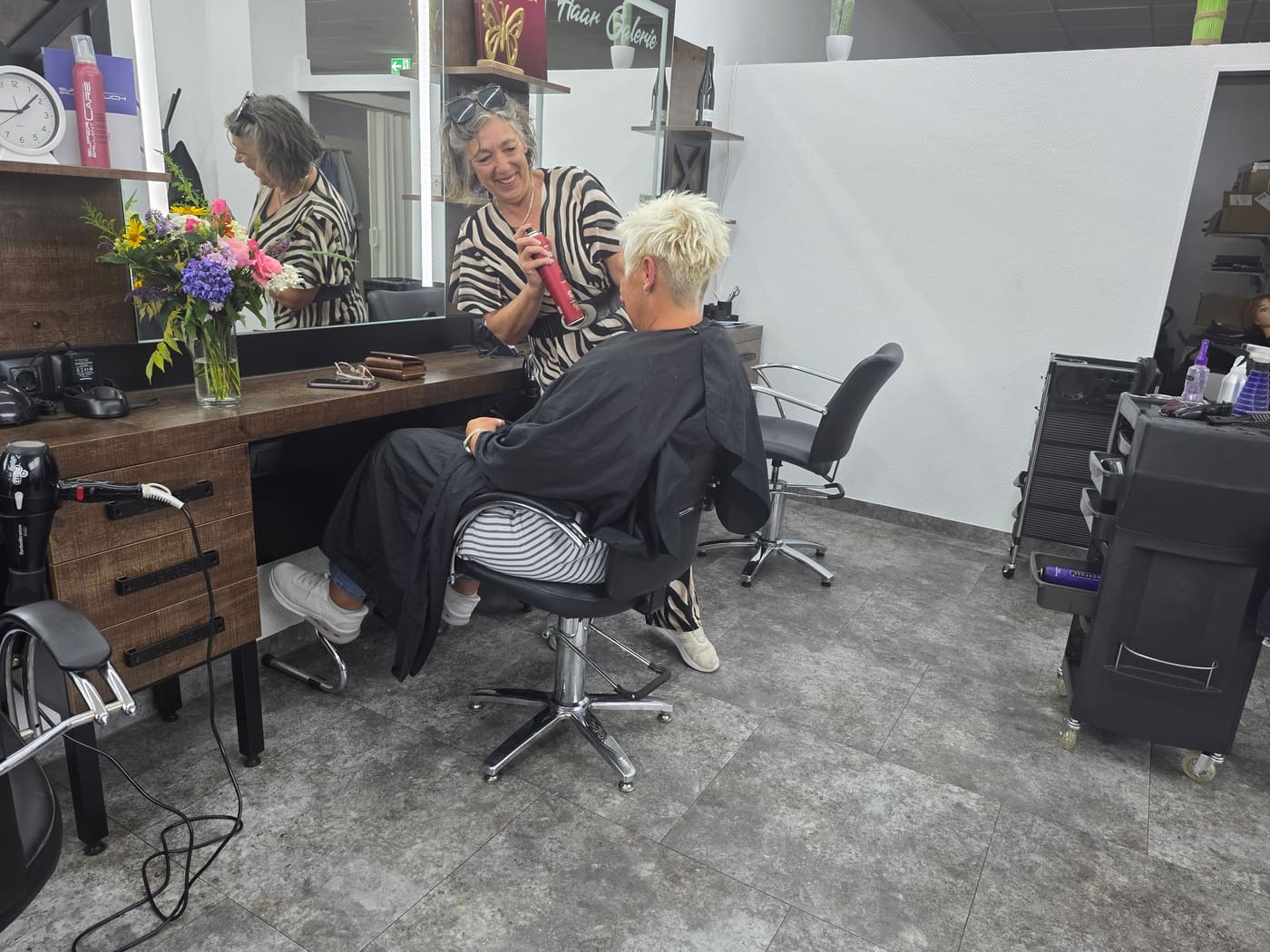 Spiegelplatz im Salon: Stylistin und Kundin